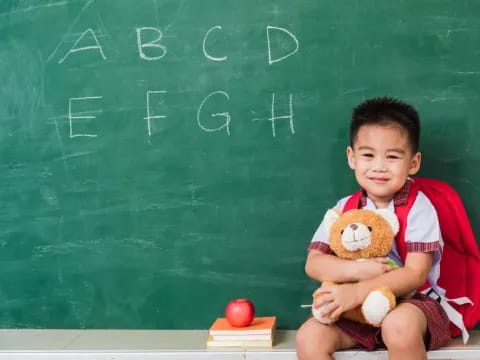 a young boy holding a teddy bear