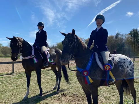 a couple of women riding horses