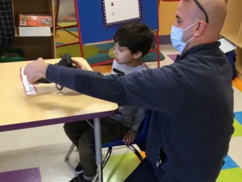 a man helping a boy with a table