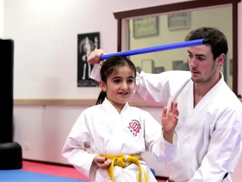 a man and a girl in karate uniforms