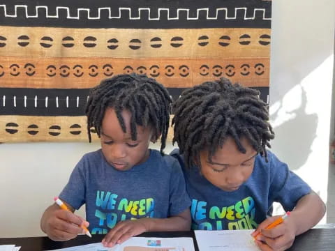 a few young boys writing on paper