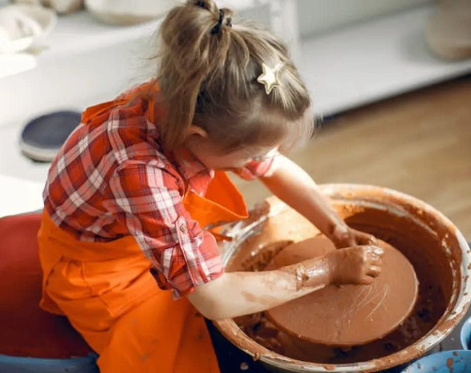a little girl washing a chicken