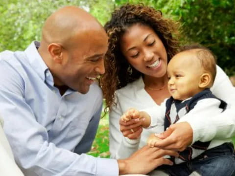 a man and woman holding a baby