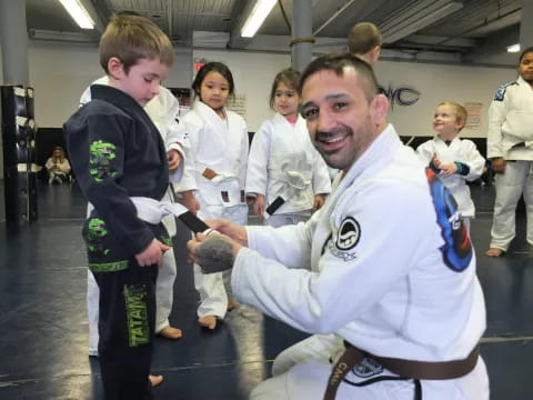 a man in a karate uniform with a boy in the background