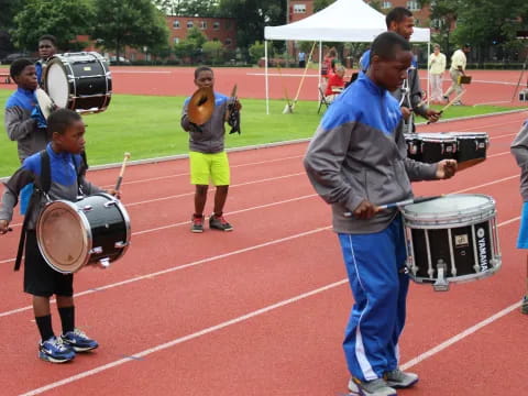 a person and a boy playing drums