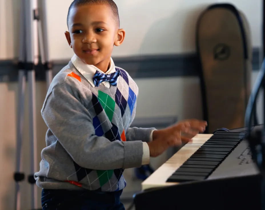 a young boy playing a piano