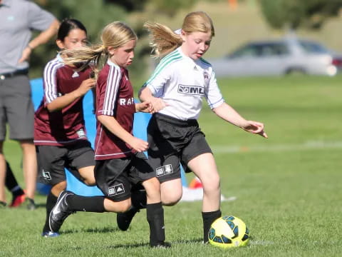girls playing football on a field
