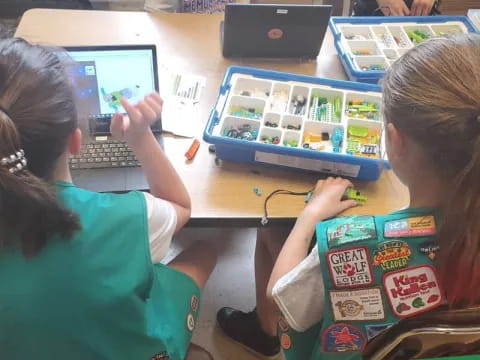 a few young girls using laptops