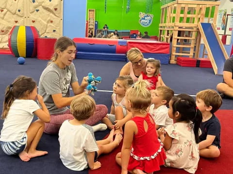 a group of children sitting on the floor in a playroom