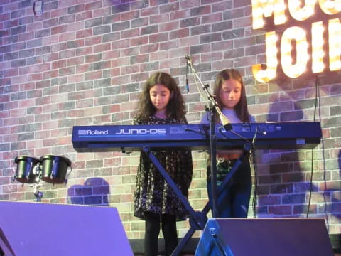 two women playing the piano