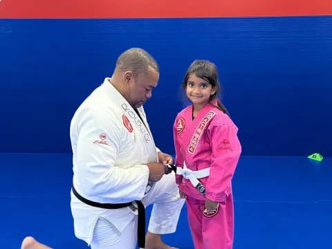 a man and a girl in karate uniforms