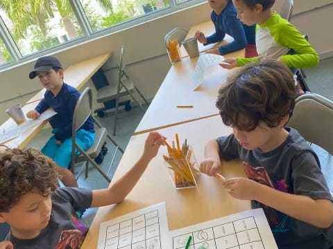 a group of children sitting at a table playing a board game