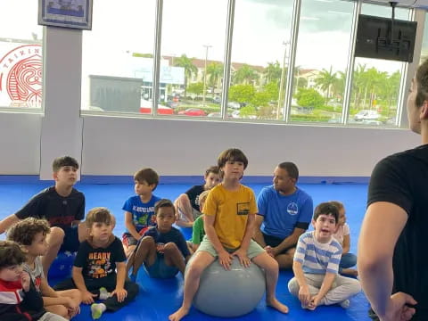 a group of people sitting on a mat posing for the camera