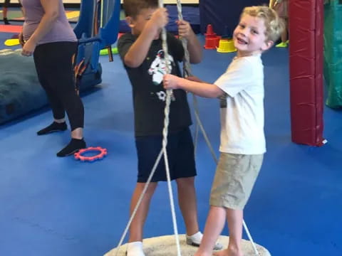 a couple of kids playing on a gym toy