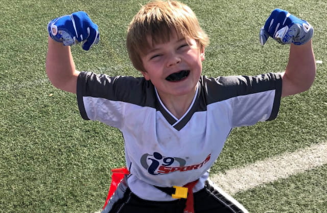 a boy with his arms up and legs up in the air