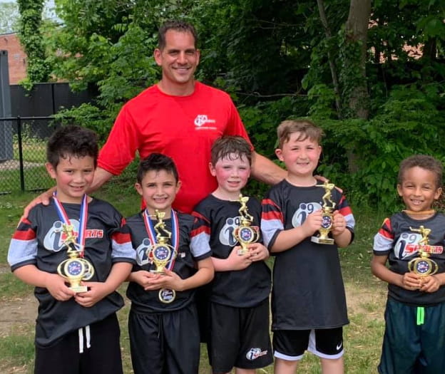 a group of boys posing for a picture with a trophy