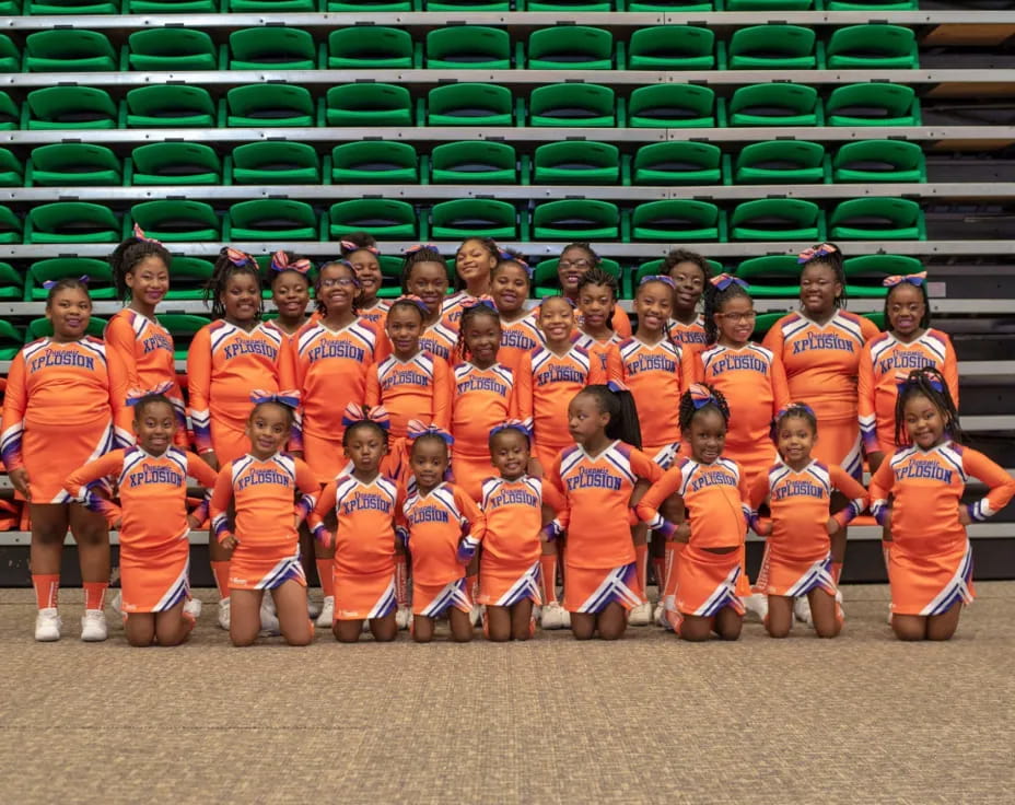 a group of kids in orange uniforms