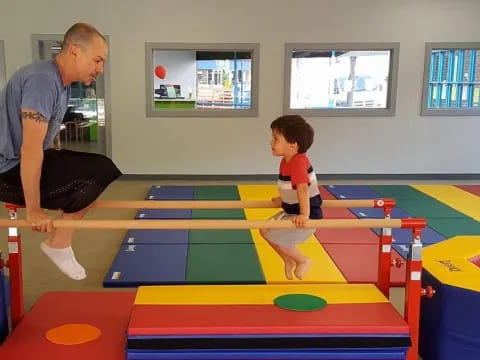 a person and a child playing on a colorful mat in a room