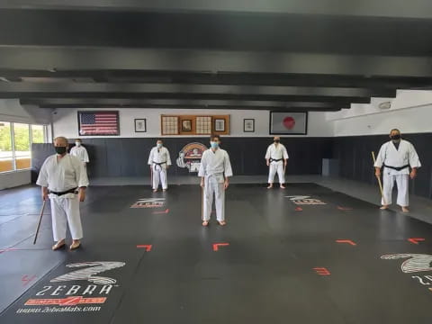 a group of people in white karate uniforms in a room