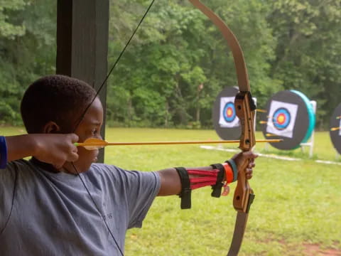 a boy shooting a bow and arrow
