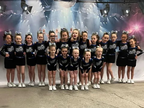 a group of girls in matching black and white uniforms