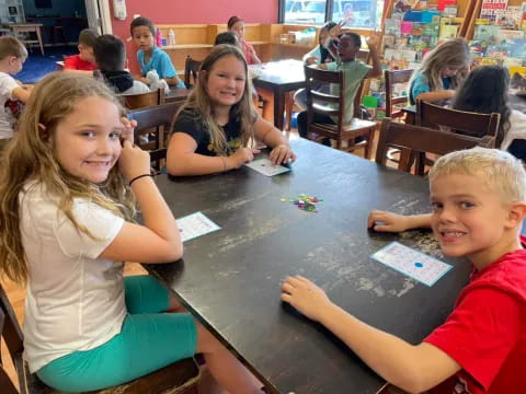 a group of children sitting at a table