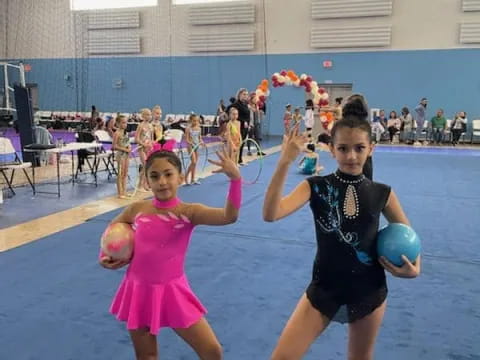 a couple of girls holding balls