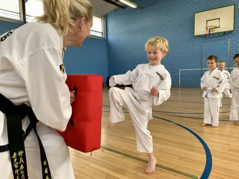 a person and a group of kids in karate uniforms