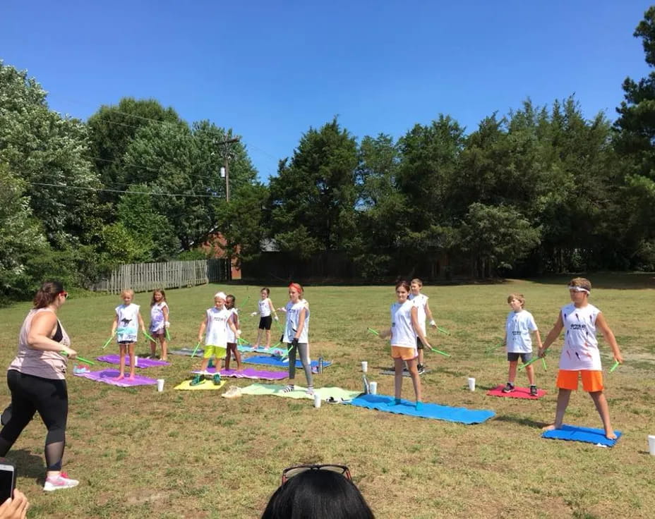 a group of people playing with kites in a field