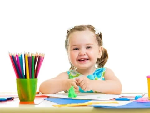 a girl coloring on a table