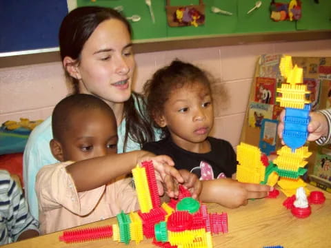 a person and two children playing with a toy train