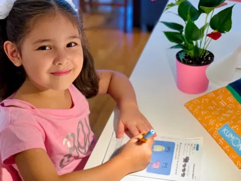 a young girl sitting at a table