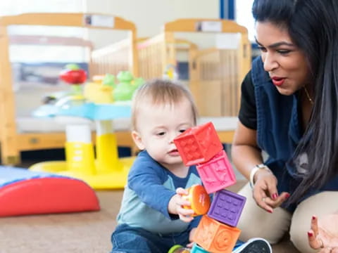a woman and a baby playing with toys