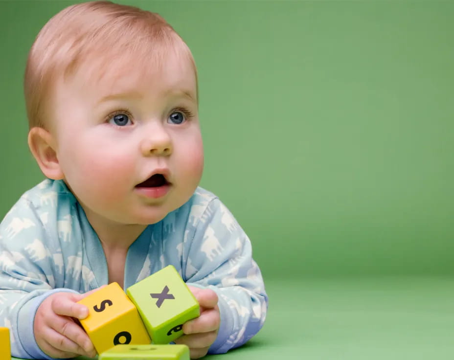 a baby holding a yellow toy