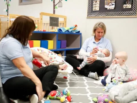 a person and a baby sitting on the floor with a baby