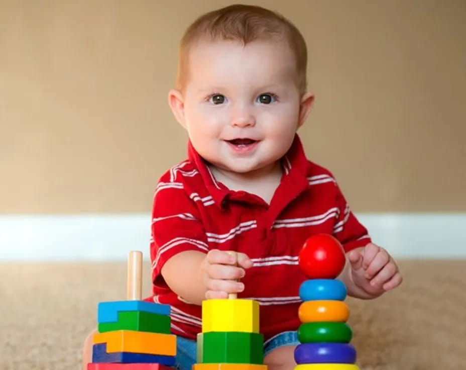 a baby sitting on a toy