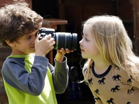 a couple of children looking through a camera