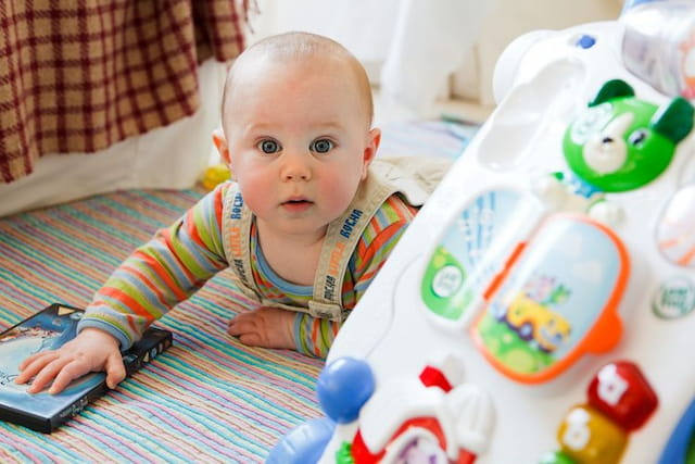 a baby playing with a remote control
