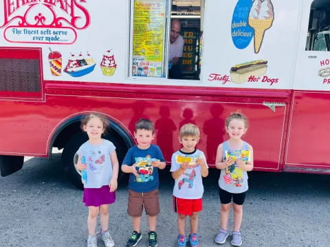 a group of kids posing in front of a food truck
