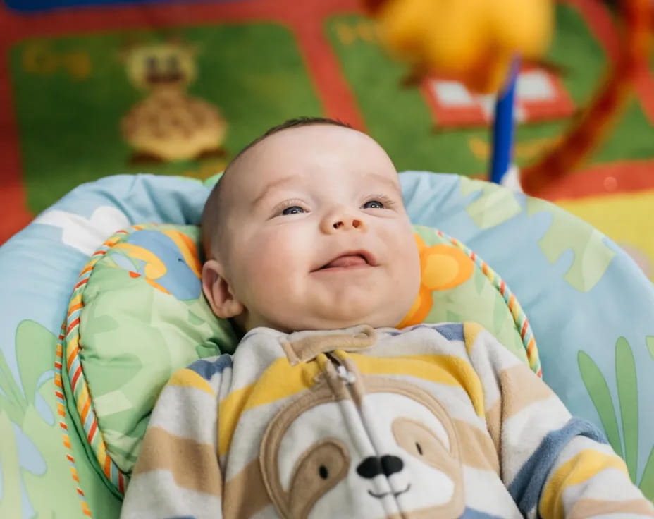 a baby lying on a colorful blanket