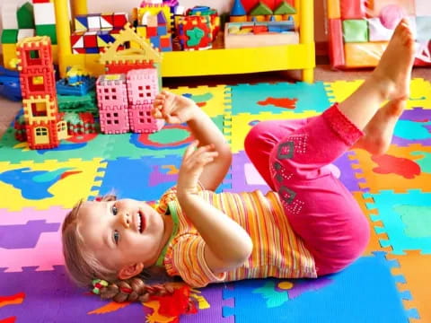 a baby lying on a colorful rug