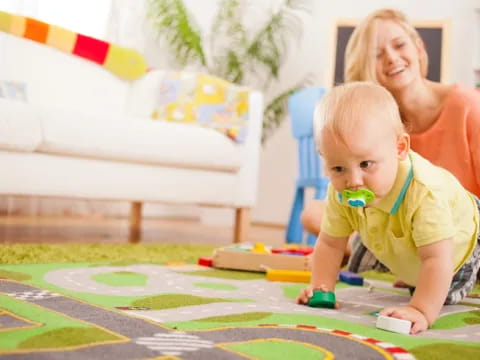 a person and a child playing on a carpet