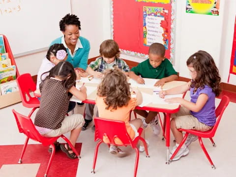 a group of children sitting around a table