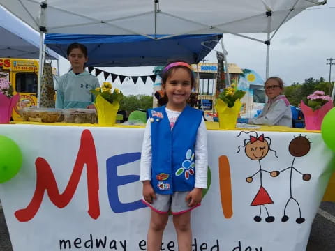a girl standing next to a banner