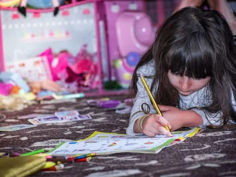 a young girl coloring on a paper