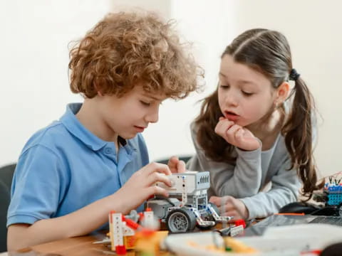 a boy and girl playing with a toy car