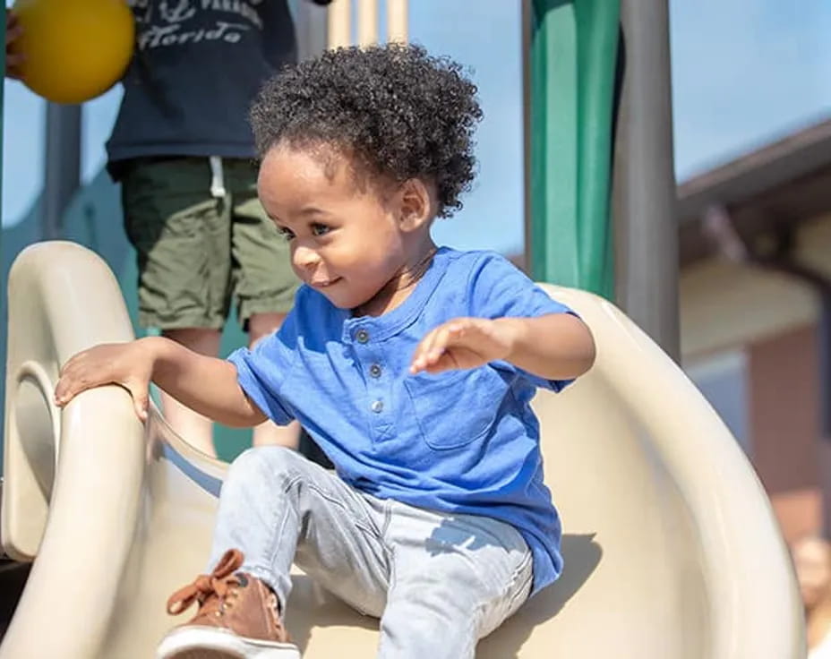 a young boy sitting on a slide