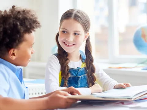 a boy and girl looking at a book