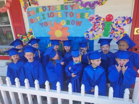 a group of people in blue graduation gowns posing for a photo