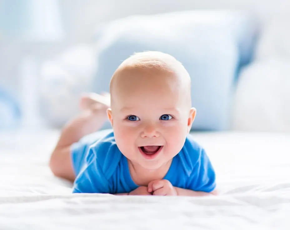 a baby lying on a bed